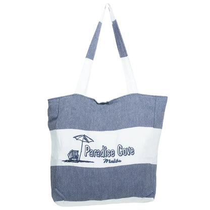 A beach tote bag with a blue-gray and white horizontal stripe design, featuring a white top band with blue-gray handles and a white front panel printed with 'Paradise Cove Malibu and a small beach umbrella and chair graphic.
